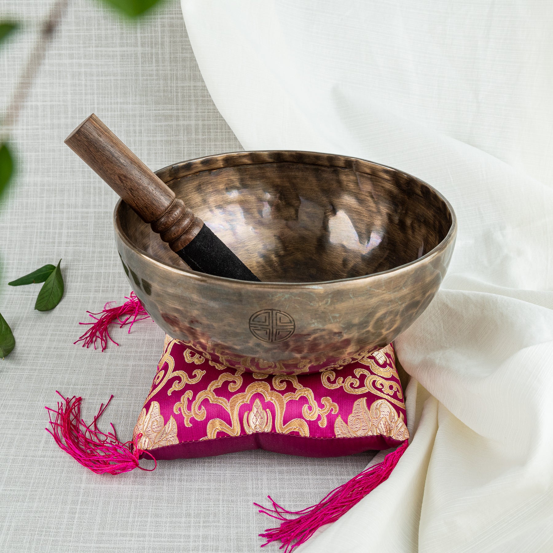 Singing bowl with mallet and pink pillow